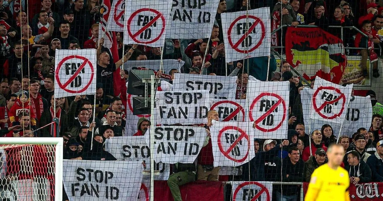 A stand filled with hand-painted “STOP FAN ID” placards carrying a crossed-out sign.