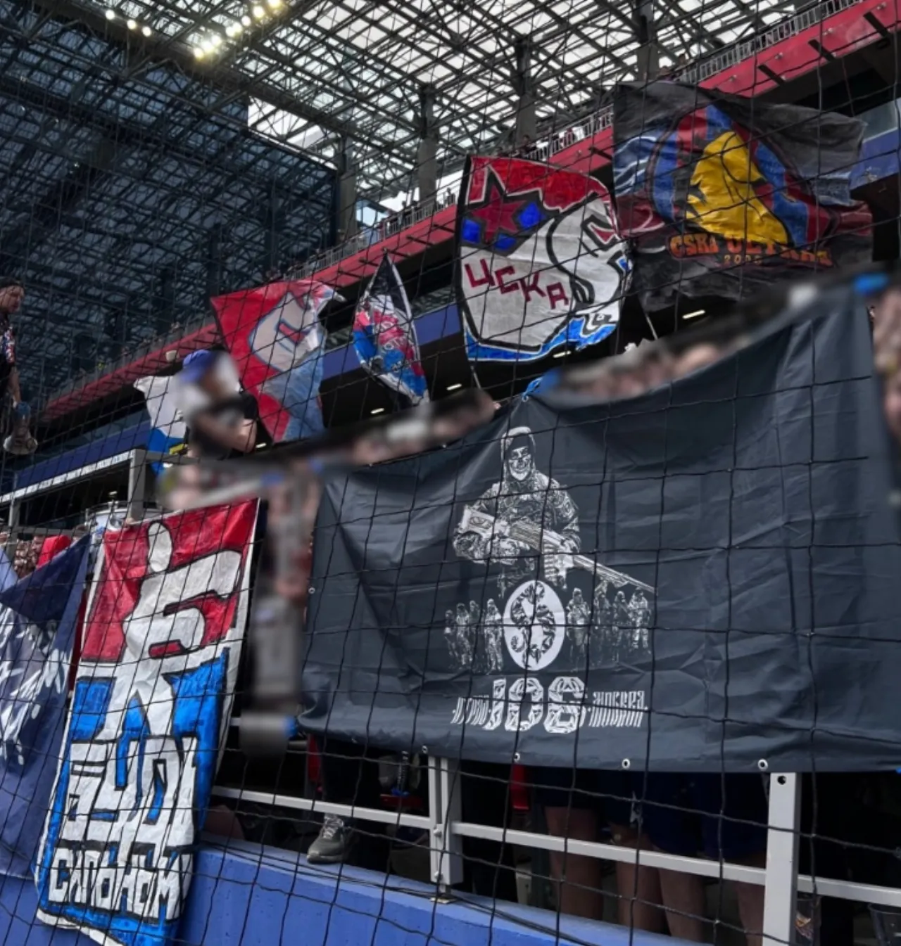 A stand with CSKA flags and a large dark banner: a masked figure and the number 106.
