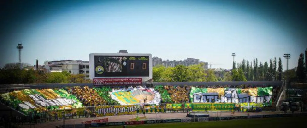 The same display from the stands: a whole tier in green and yellow, above it the scoreboard with FC Kuban’s sponsor and the score 0:0.